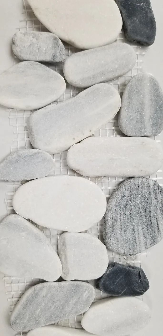 Close-up of white and gray oval river stones arranged in a mosaic pattern