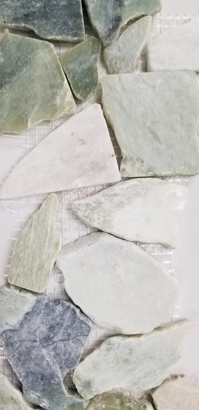 Close-up of irregular pale green, white, and gray stone tiles arranged in a mosaic pattern