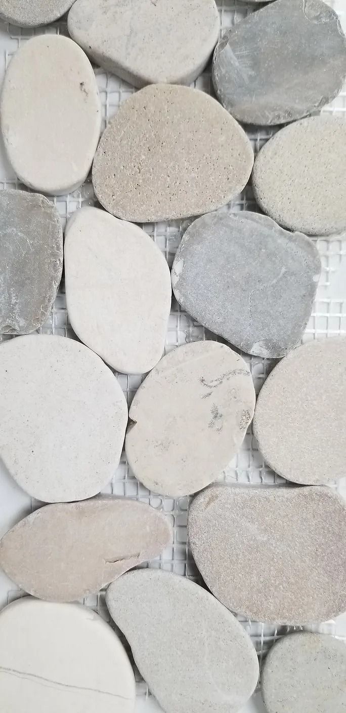 Close-up of smooth oval pebbles in white, gray, and beige tones
