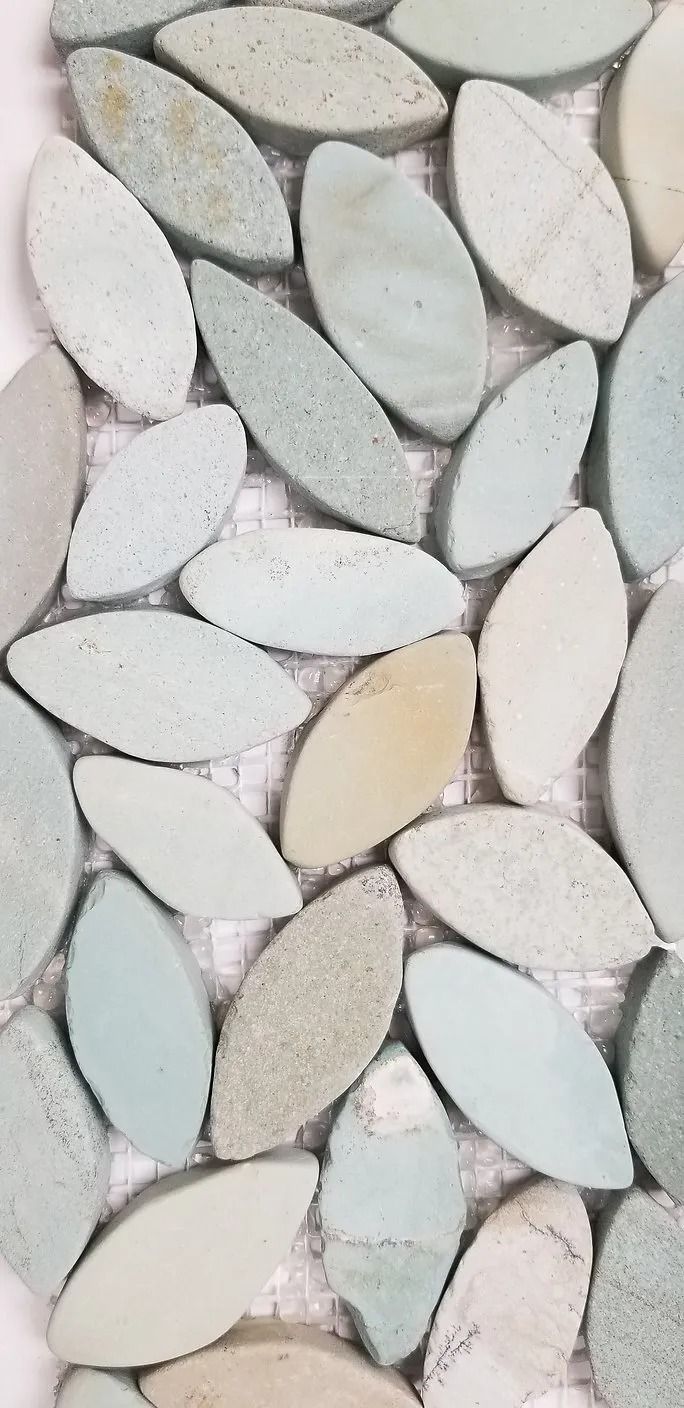 Close-up of light-colored smooth pebbles arranged in a mosaic pattern