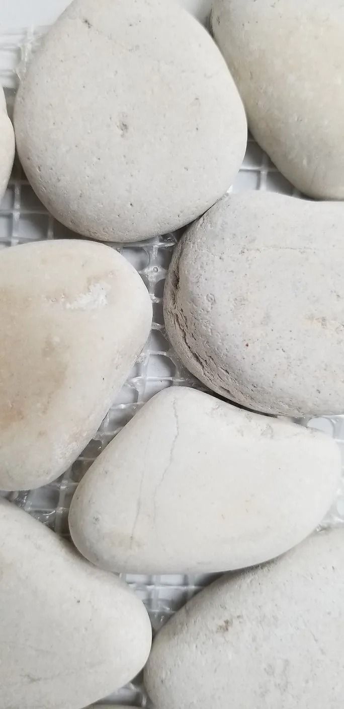 Smooth white pebbles stacked closely together in a close-up view