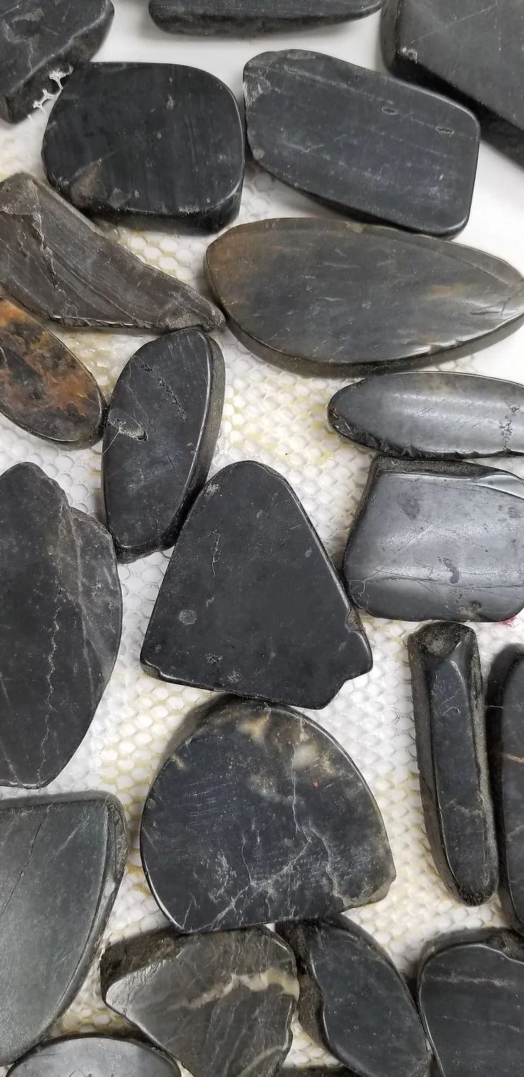 Black and gray pebbles tightly arranged on a light surface