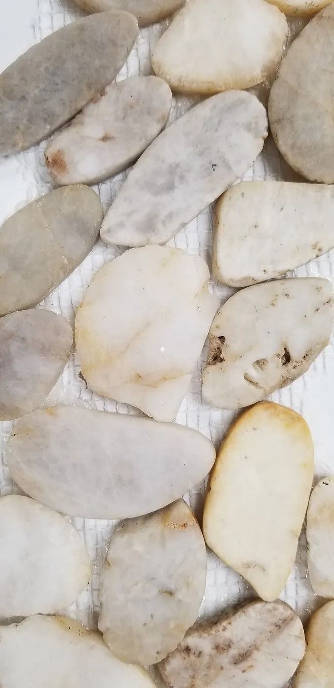 Close-up of smooth white and beige pebbles filling the frame