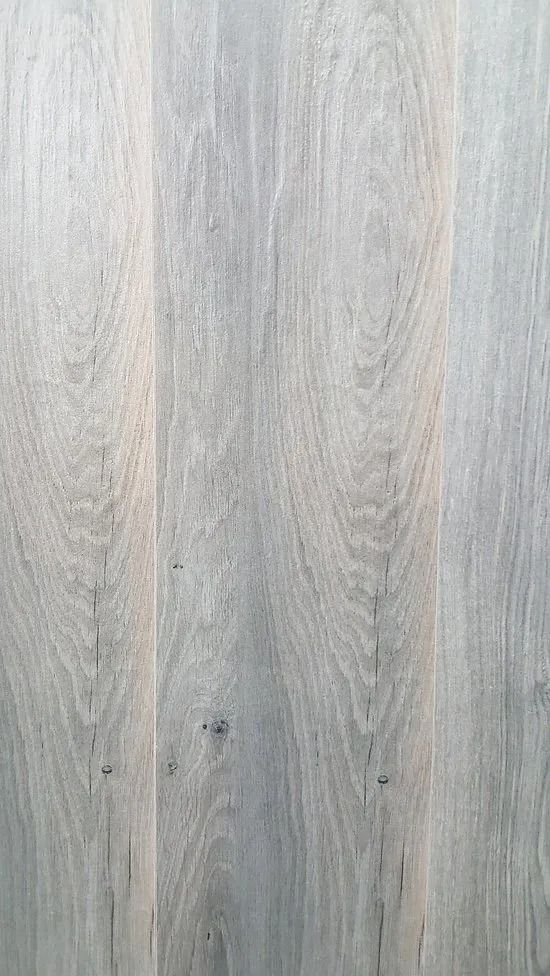 Light gray wood plank surface with subtle grain and knots