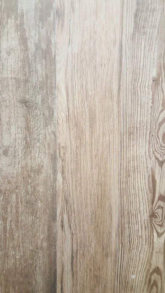Light beige wood grain floor or paneling with vertical planks and natural knots