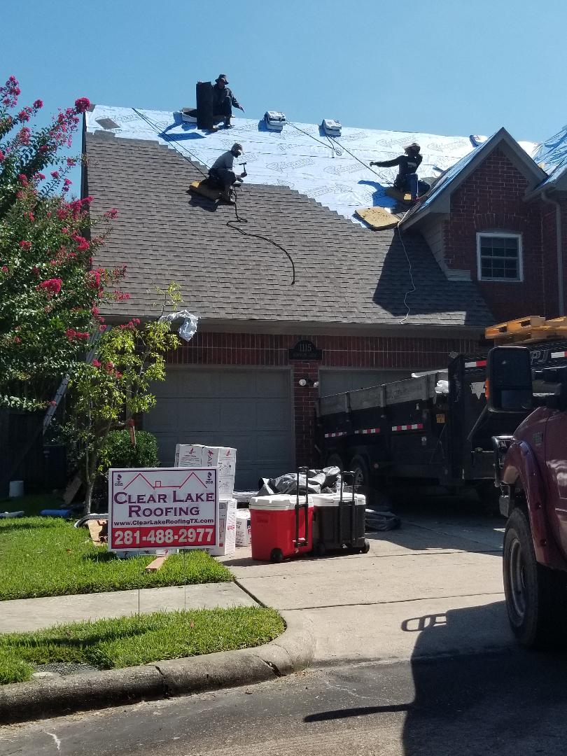 A roofer is working on the roof of a house.