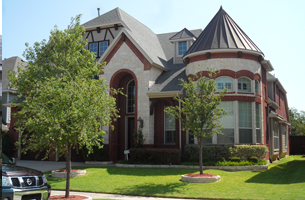 A nissan truck is parked in front of a large house