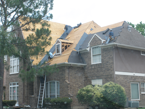 A brick house with a roof that is being repaired