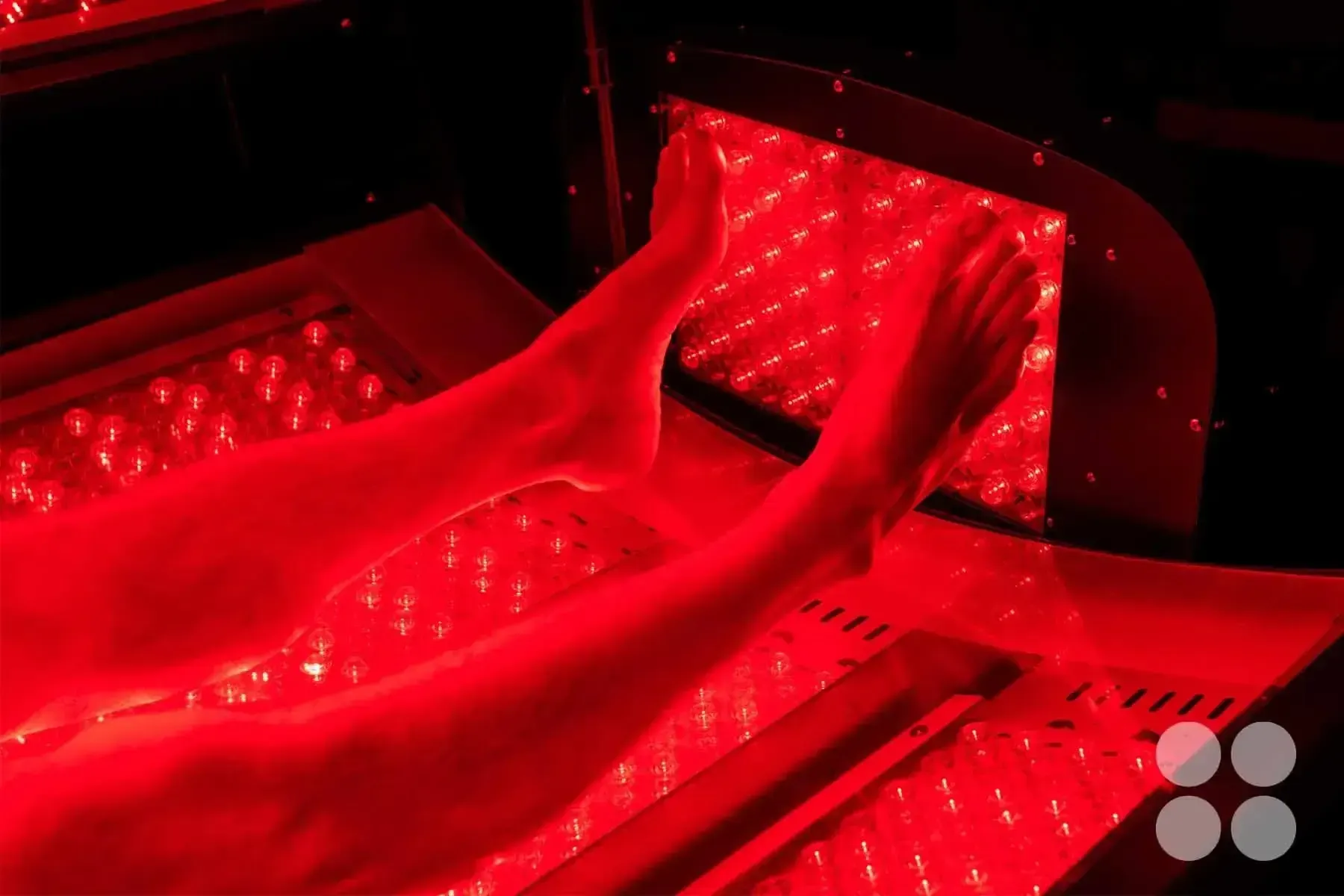 A man laying in the Max Miracle 9600 red light therapy bed receiving a treatment