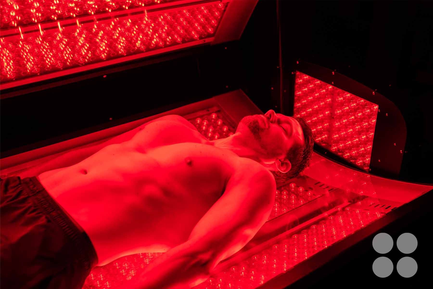 A man laying in the Max Miracle 9600 red light therapy bed receiving a treatment