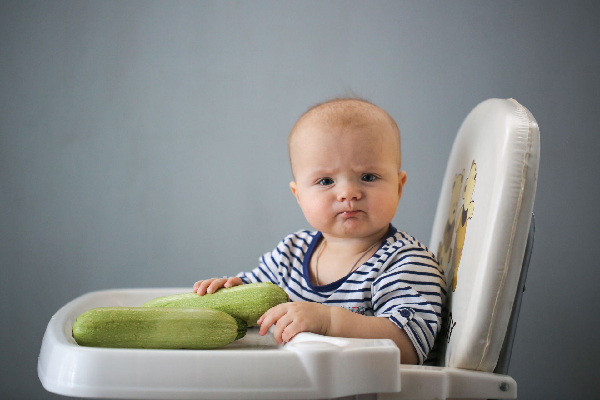 A funny baby with zucchini