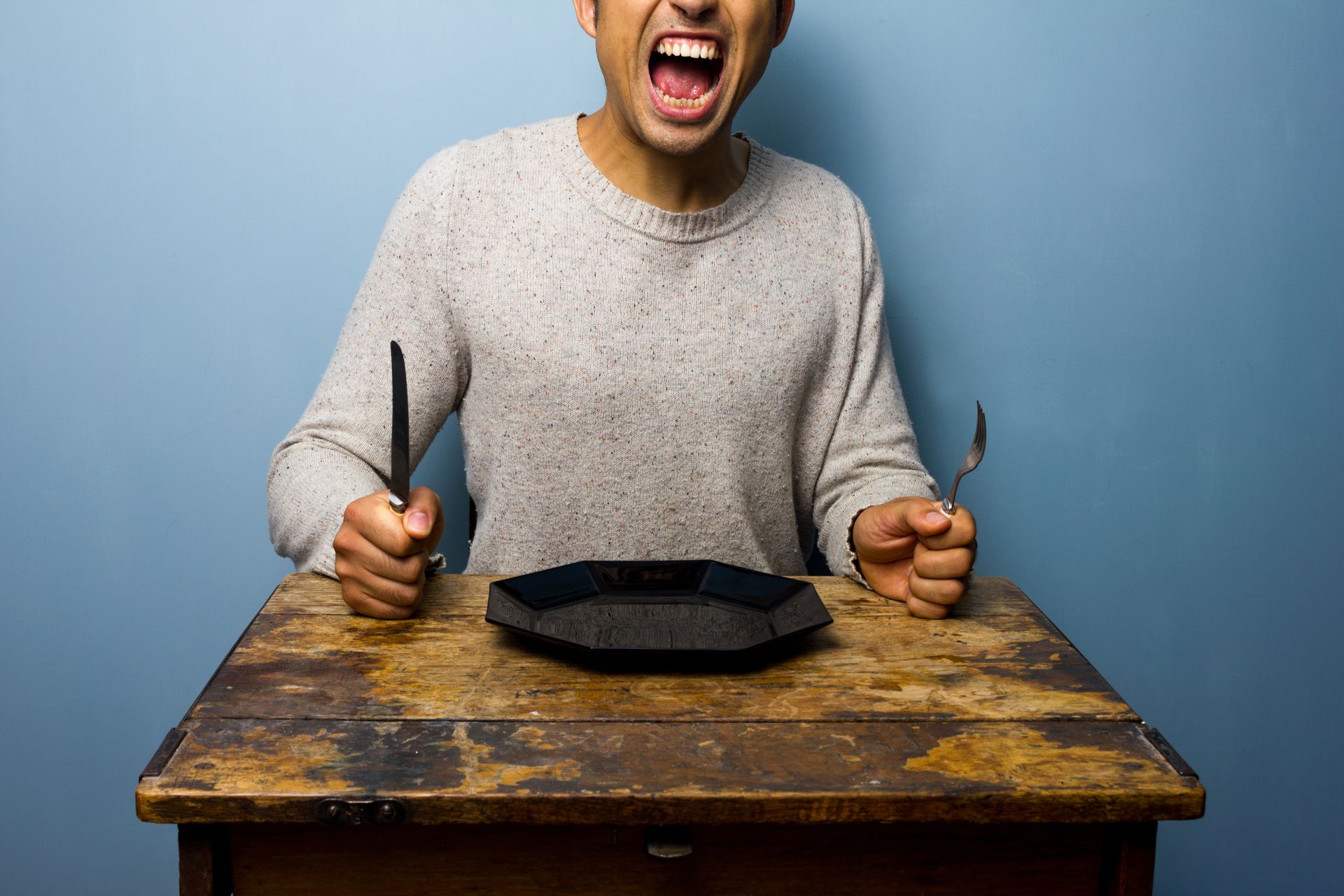 A starving man with a knife and fork