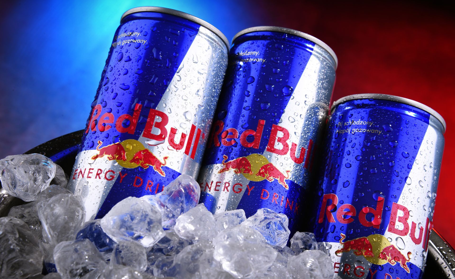 Three red bull cans in ice