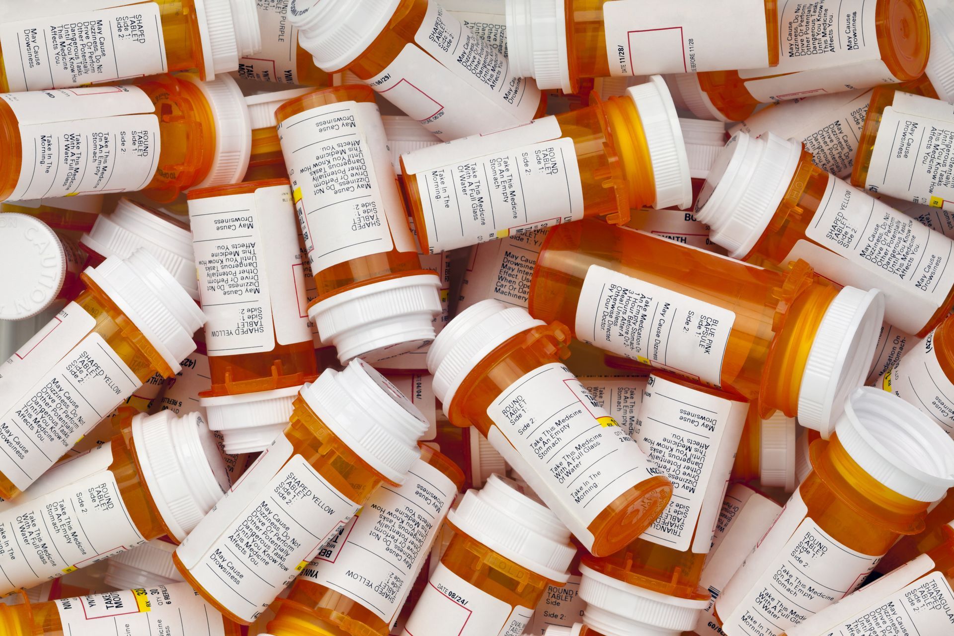 A pile of orange medication bottles