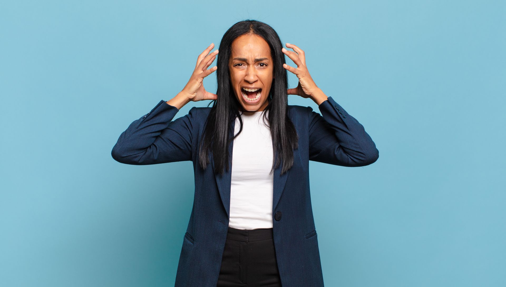 A black woman acting like she is going crazy pulling her black hair with both of her hands