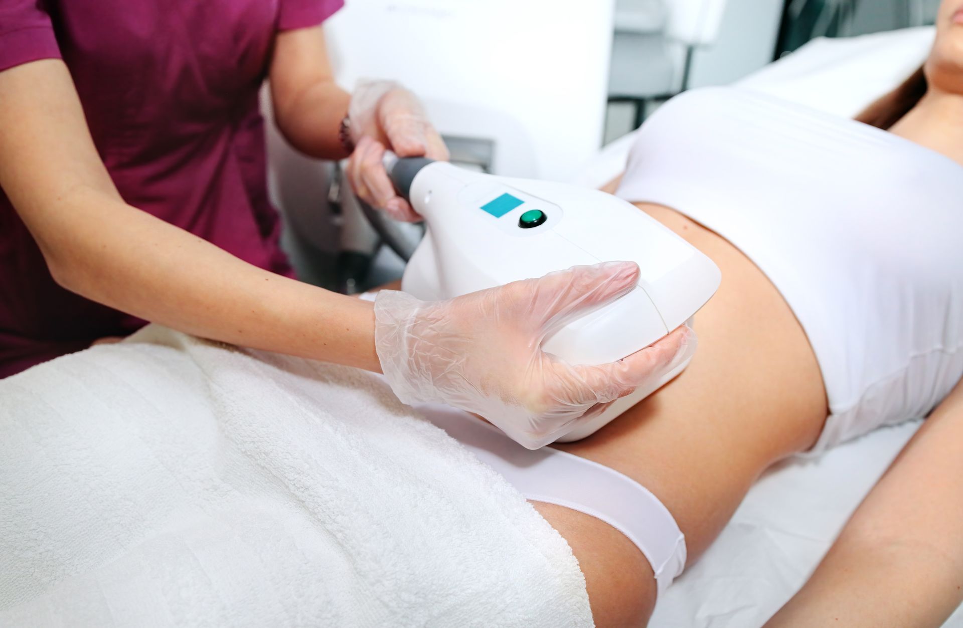 A woman receiving a cool sculpting treatment on her stomach