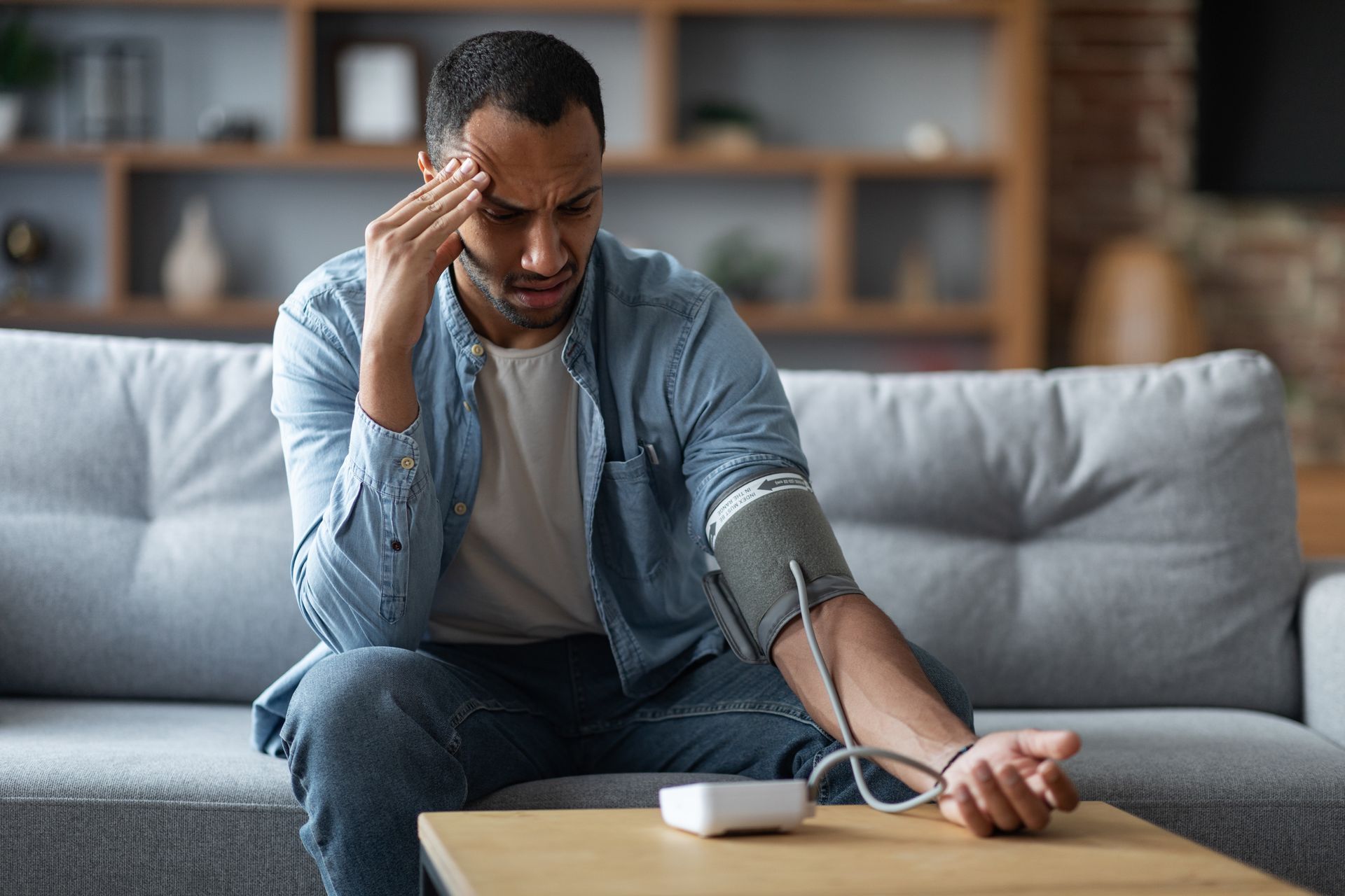 A black man taking his blood pressure with an automatic blood pressure cuff