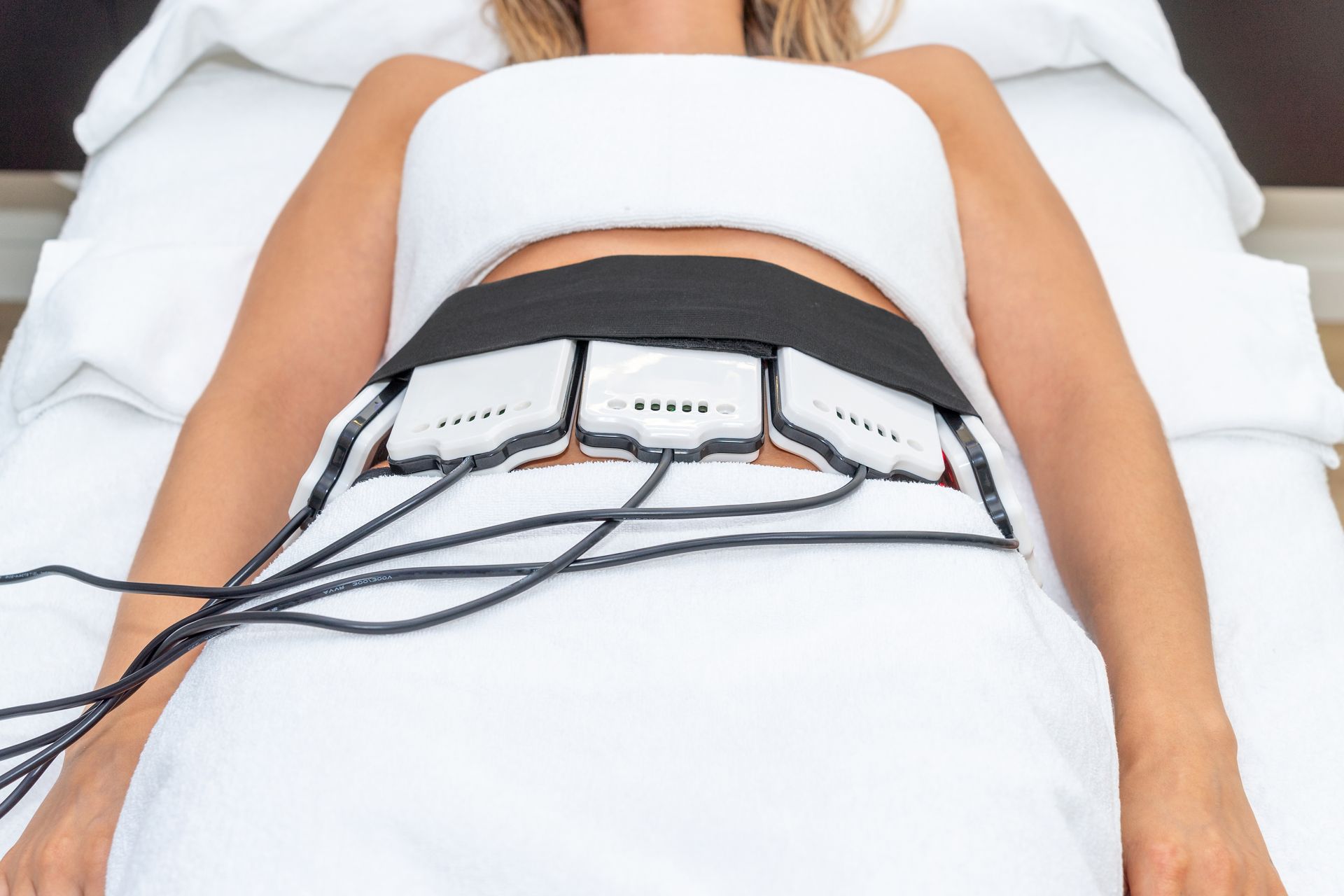 A white woman having a non-invasive laser lipo session on her stomach