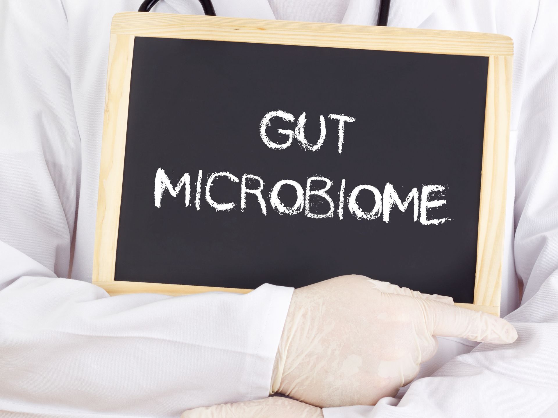 A doctor holding a sign that says gut microbiome