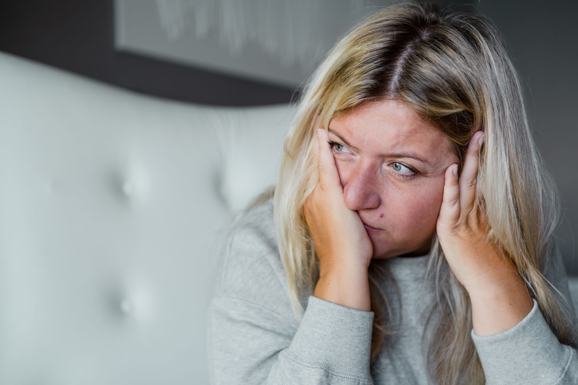 A depressed white woman with her face in her hands