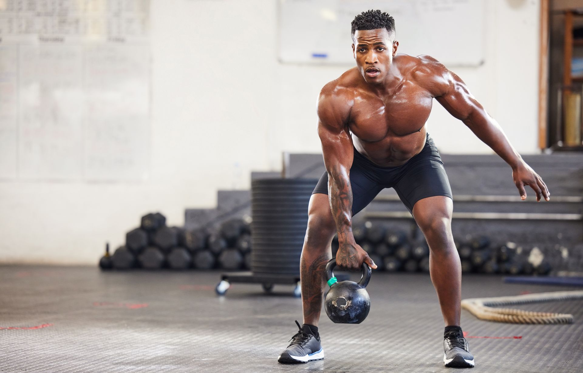 A very fit and muscular black man working out with his shirt off