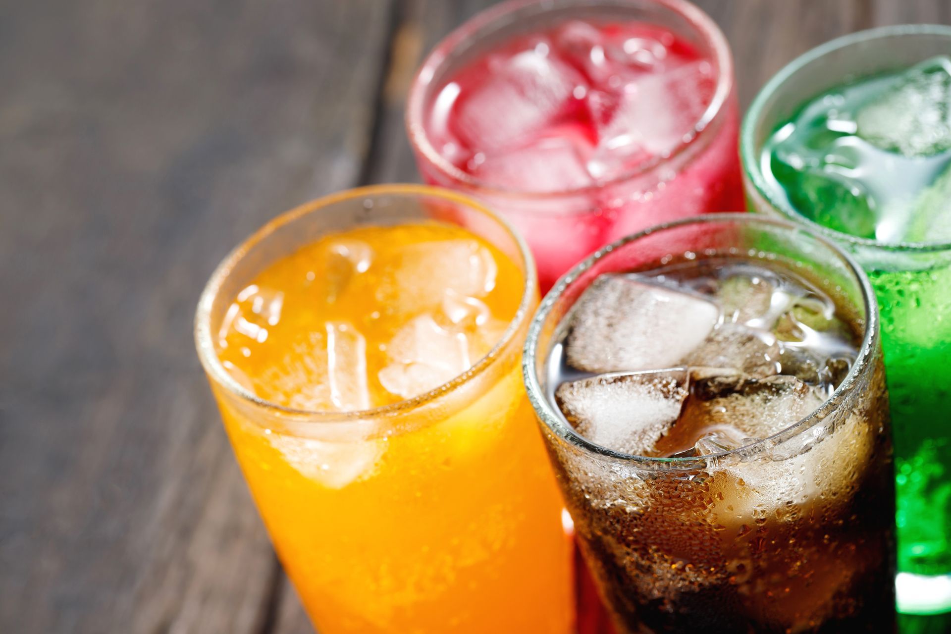 Three glasses of different colored soda