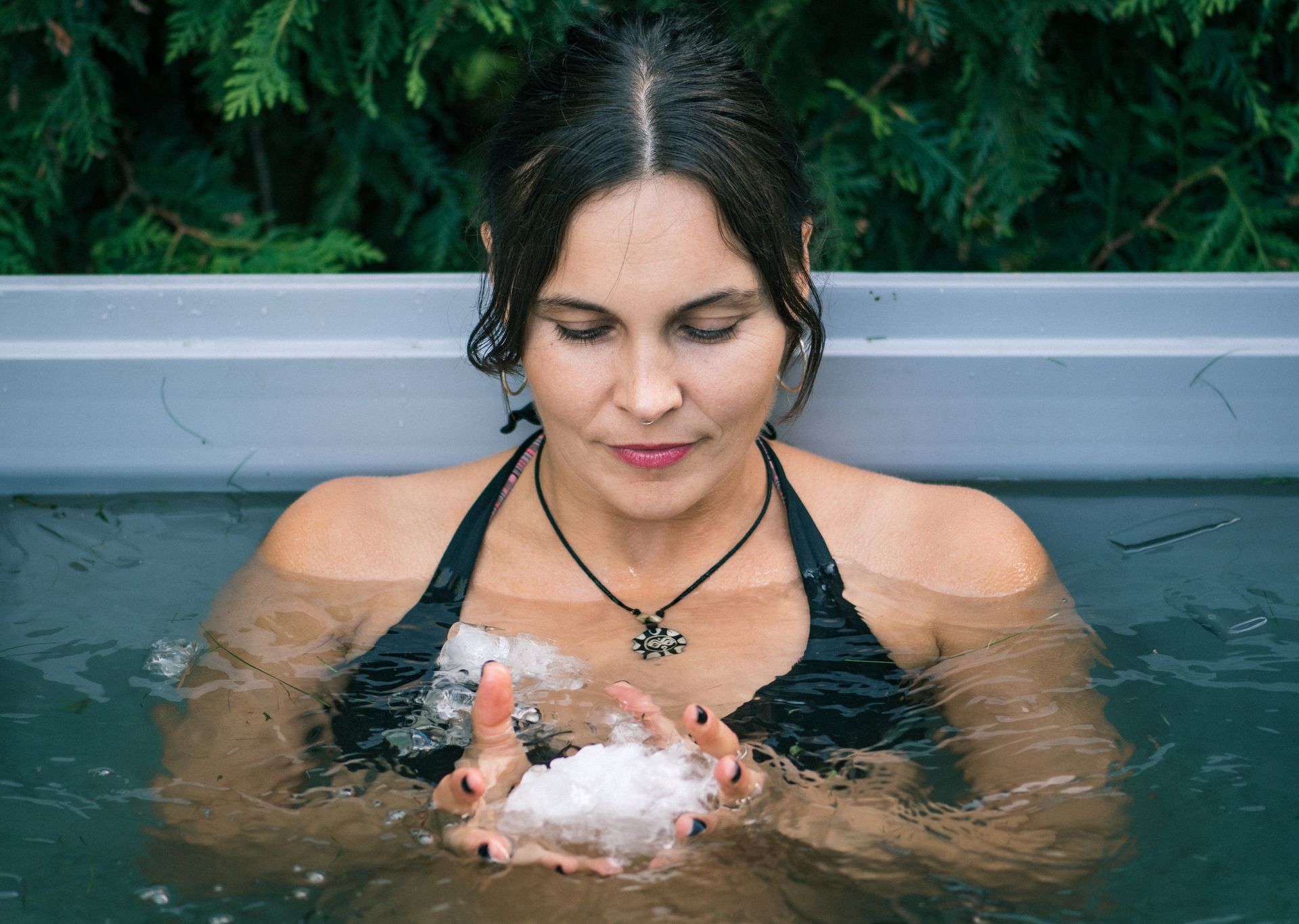 A woman taking an ice bath holding ice in the water