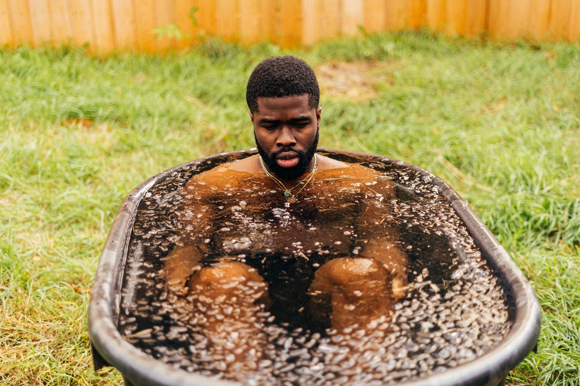 A black man taking an ice bath