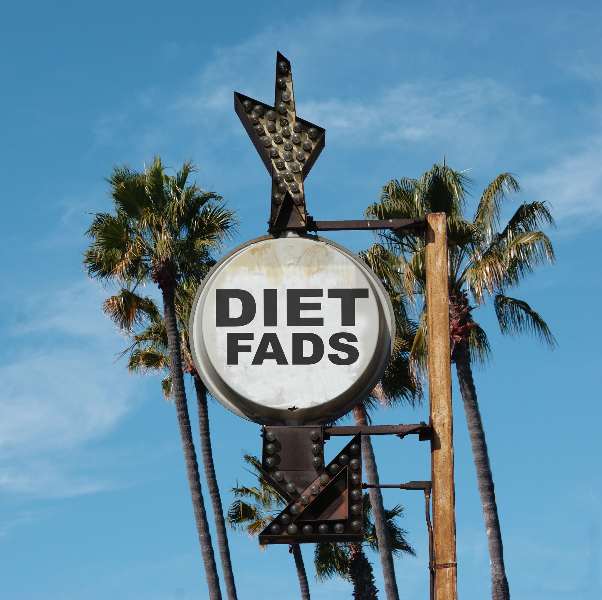 A fad diet sign with palm trees around it