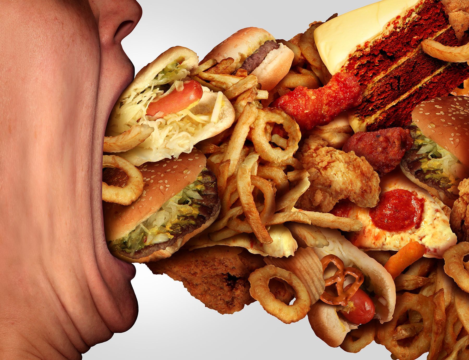 A person shoving a massive amount of junk food in their mouth