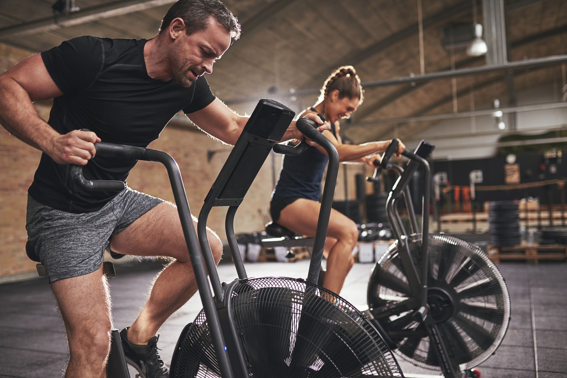 A man and a woman on exercise bikes