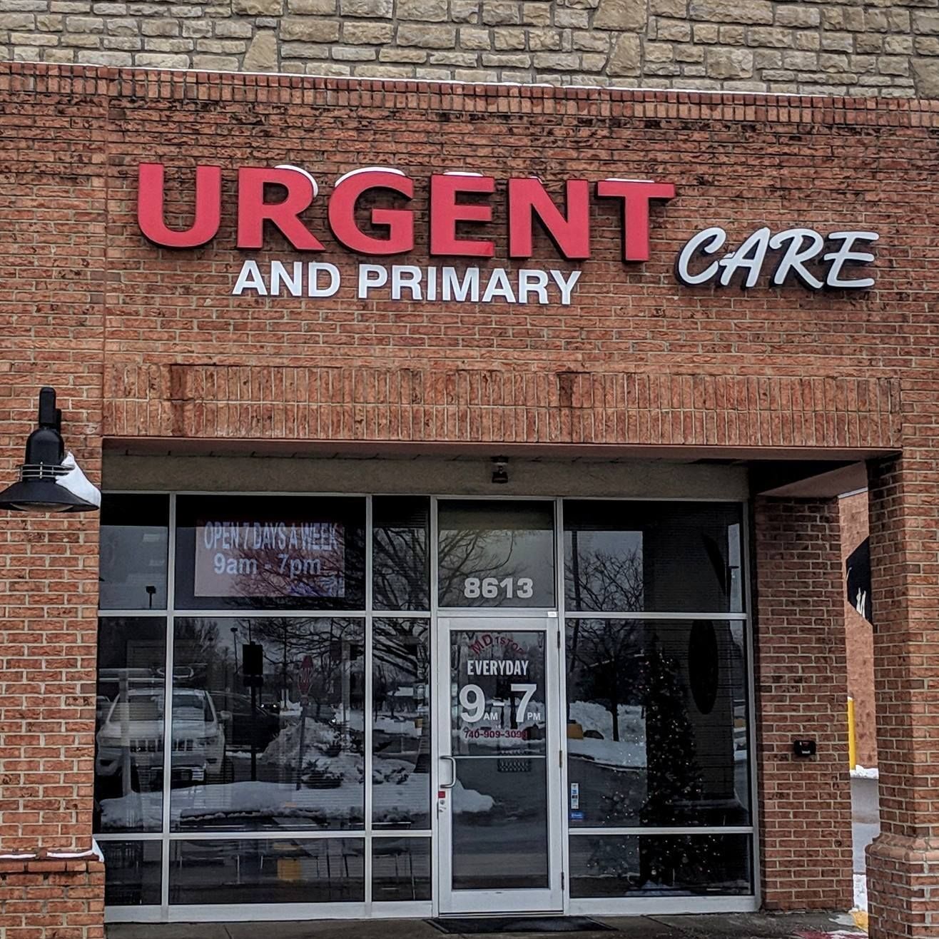 Exterior of an urgent care clinic with red and white lettering. Open 9-7. Building is brick with glass doors and windows.