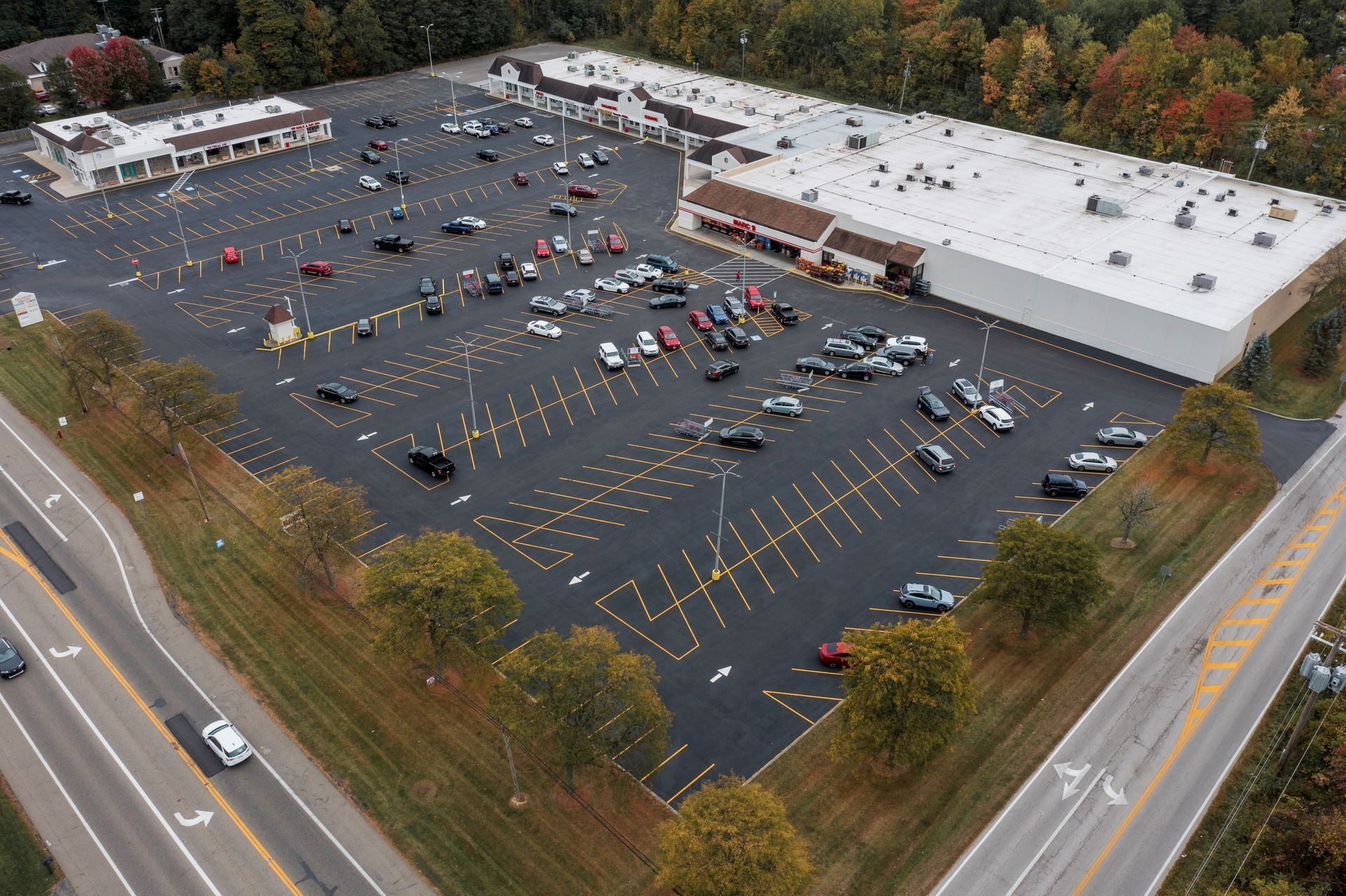 An aerial view of a parking lot with a large building in the background.