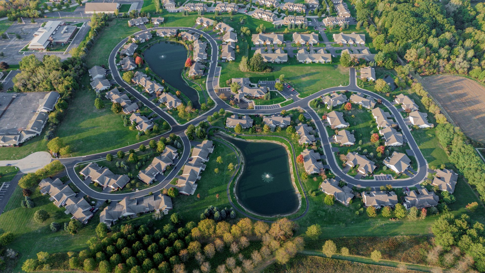 An aerial view of a residential neighborhood with a lake in the middle.