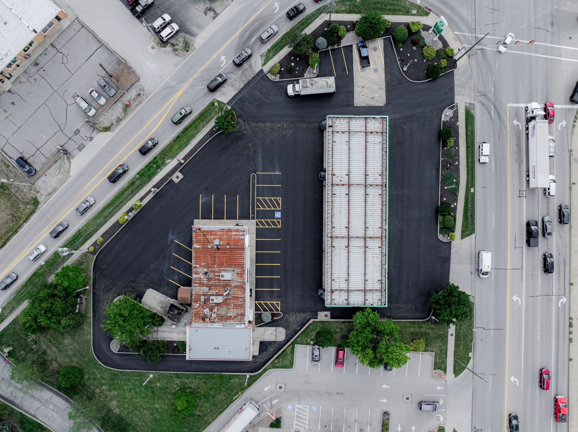 An aerial view of a gas station and parking lot after new asphalt paving.