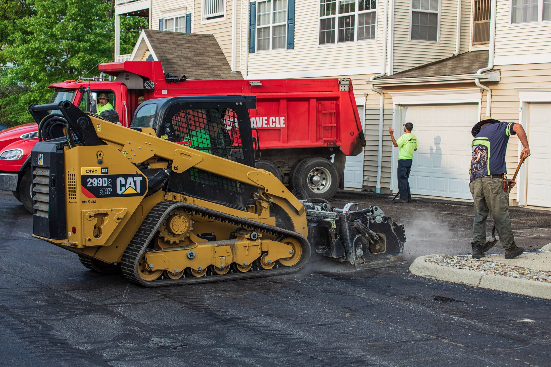 A man is standing next to a bulldozer and a dump truck.