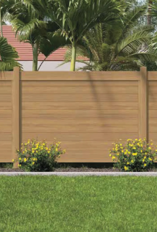 Wooden fence with tropical palms and yellow flowers above a green lawn