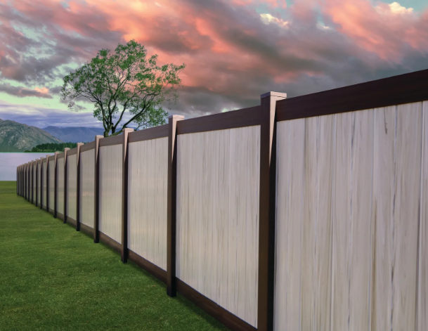 Long wooden fence along a grassy yard under a pink sunset sky