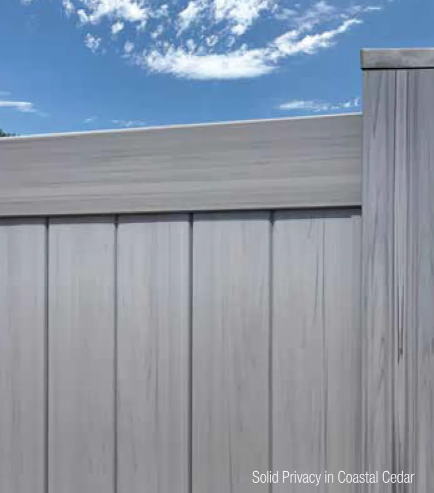 Gray privacy fence under blue sky with clouds