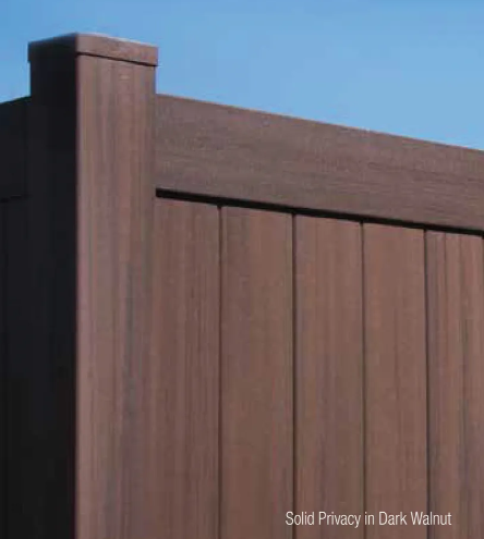 Brown wood privacy fence with vertical slats and a square post against a blue sky