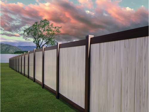 Long wooden fence along a grassy yard under a pink cloudy sky at sunset