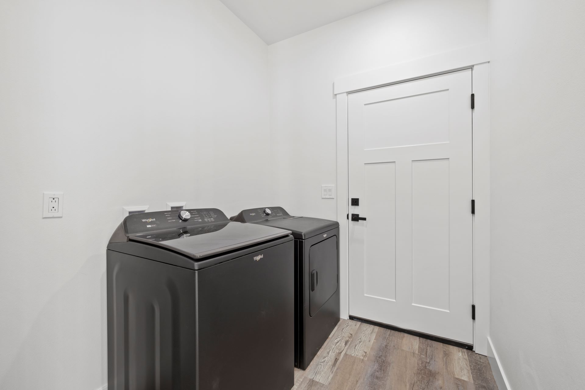 A laundry room with a washer and dryer and a door.