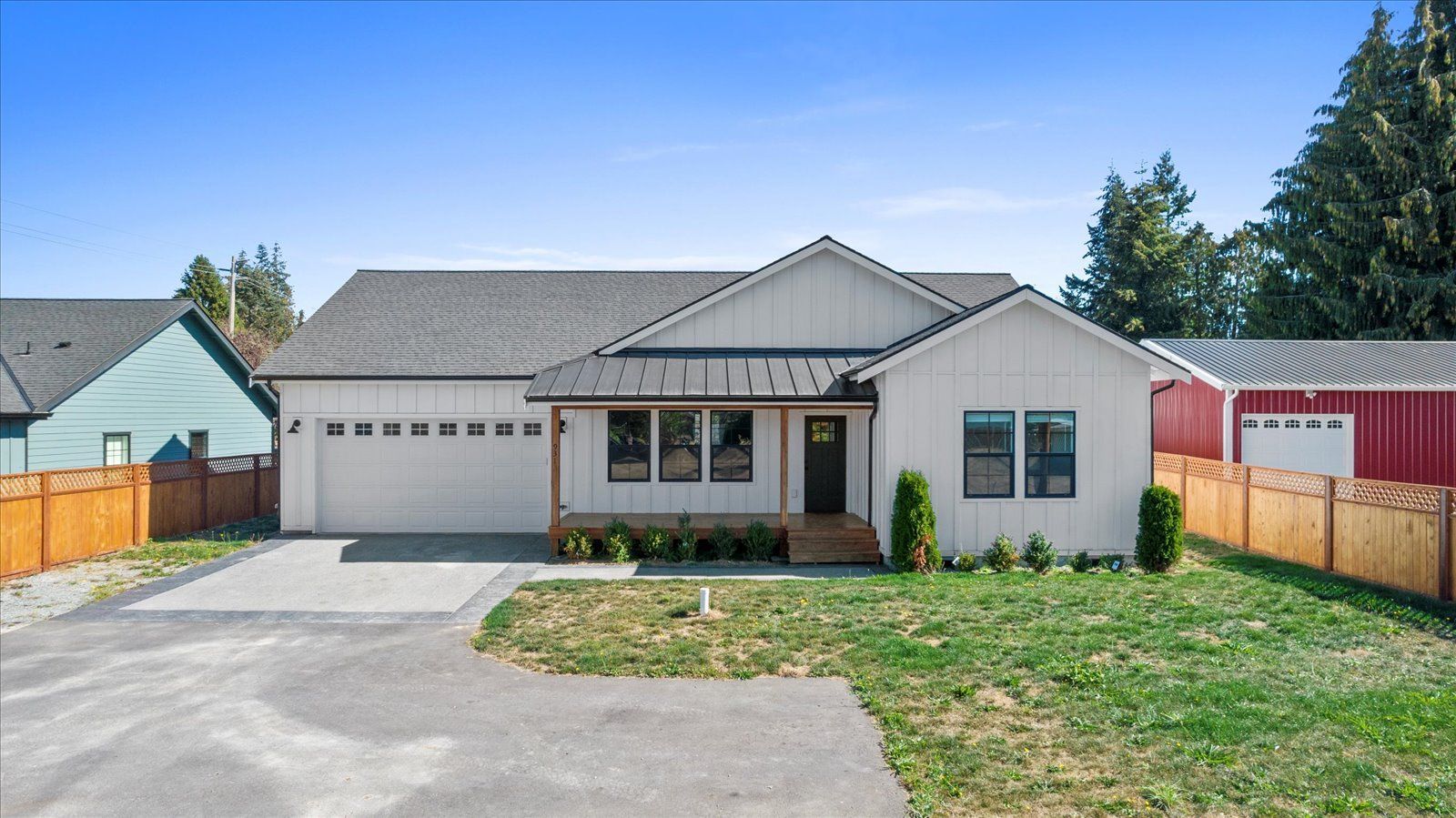 A white house with a red barn in the background is for sale.