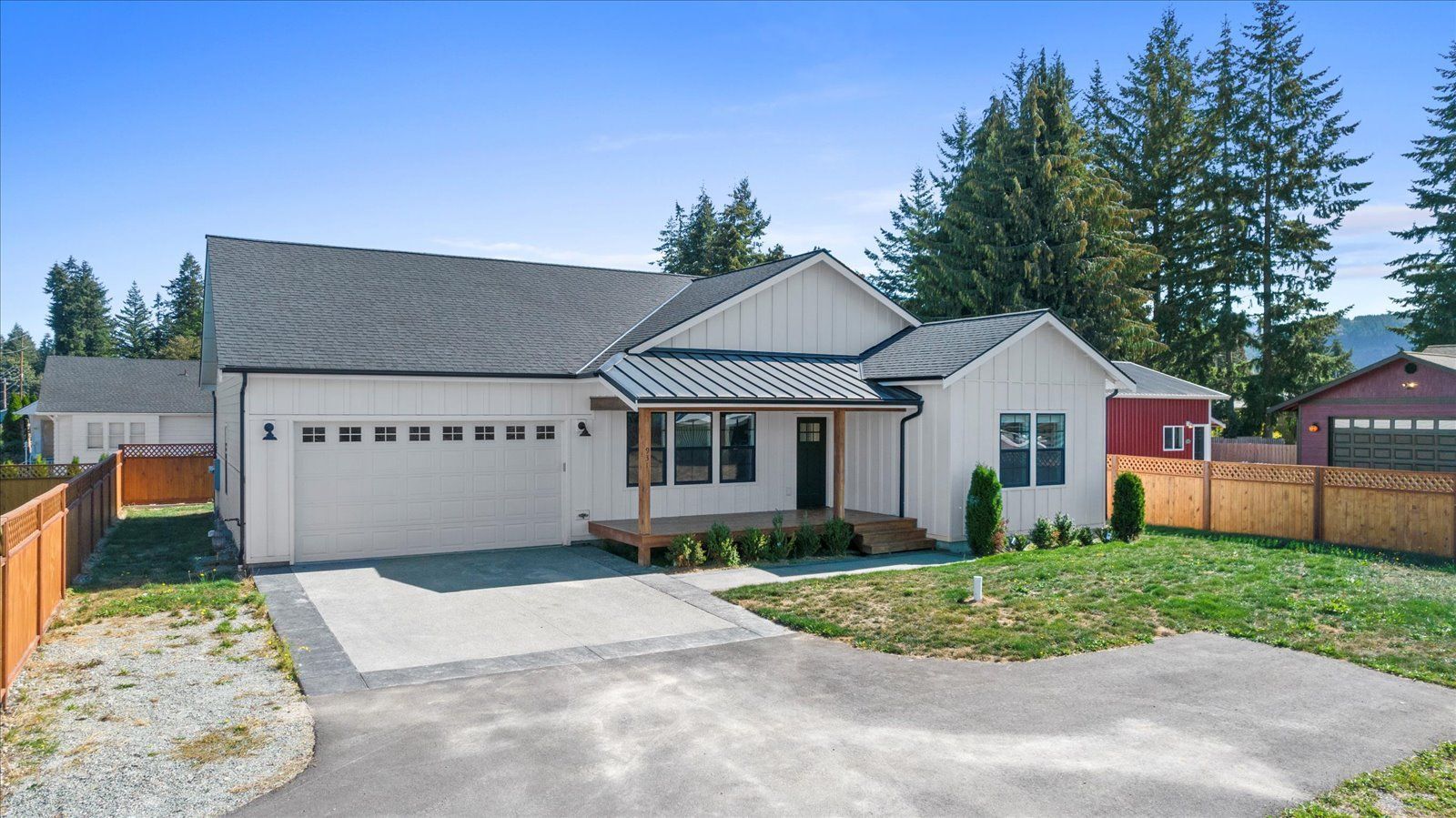 A white house with a gray roof and a driveway