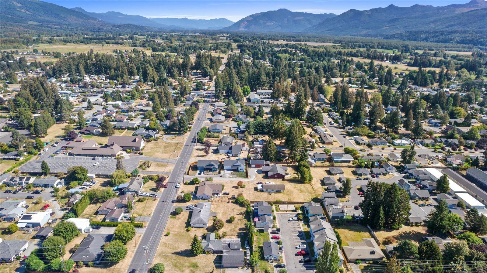 An aerial view of a small town with mountains in the background.