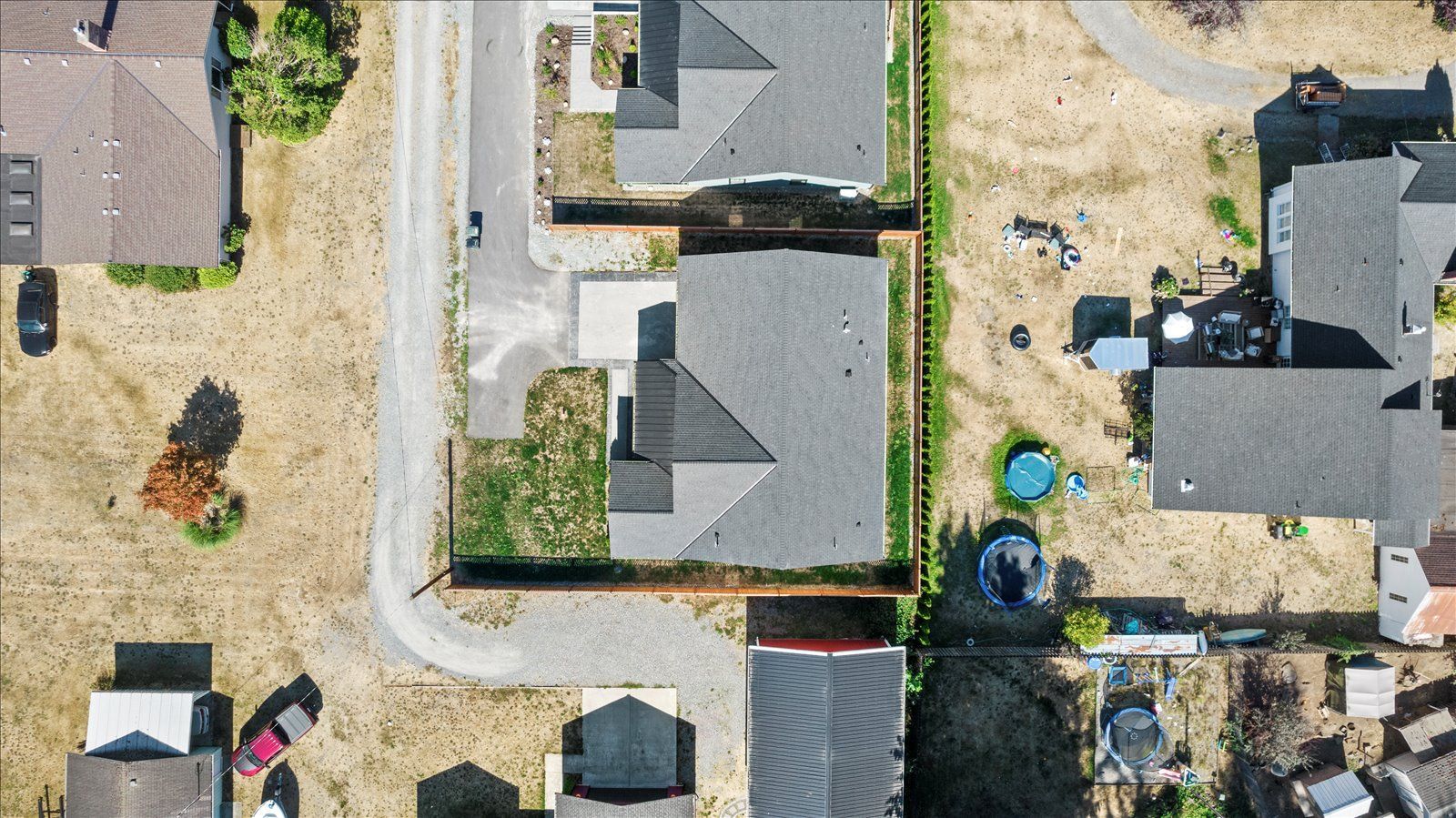 An empty bedroom with hardwood floors and two windows.