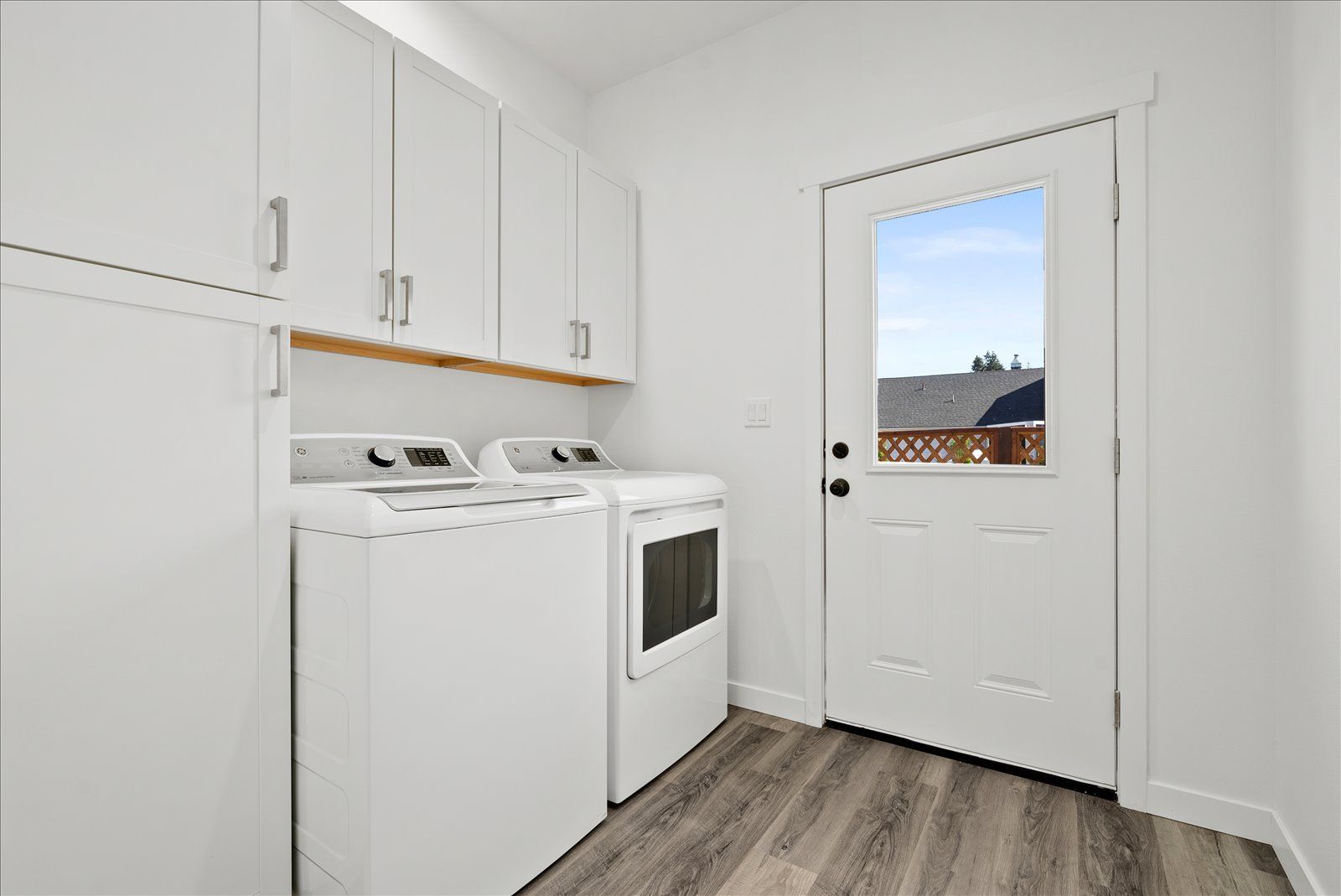 A laundry room with a washer and dryer and a window.