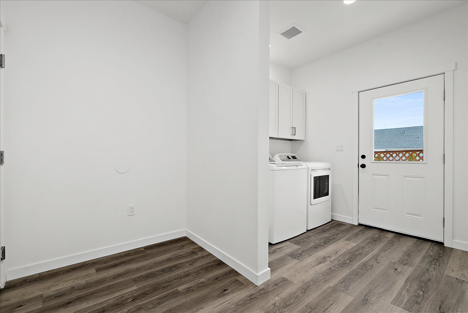 A laundry room with a washer and dryer and a window.