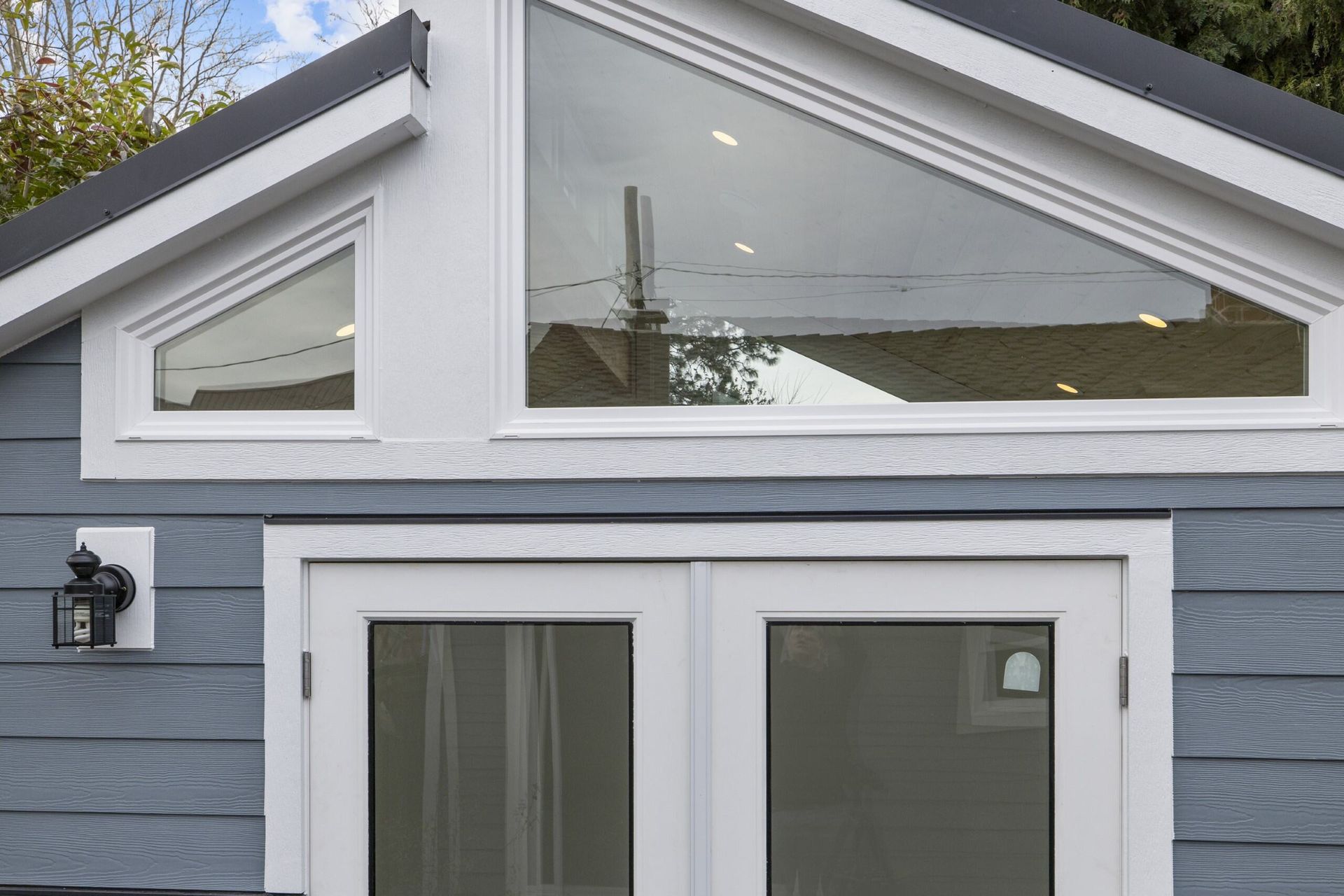 A blue house with a white door and a large window.