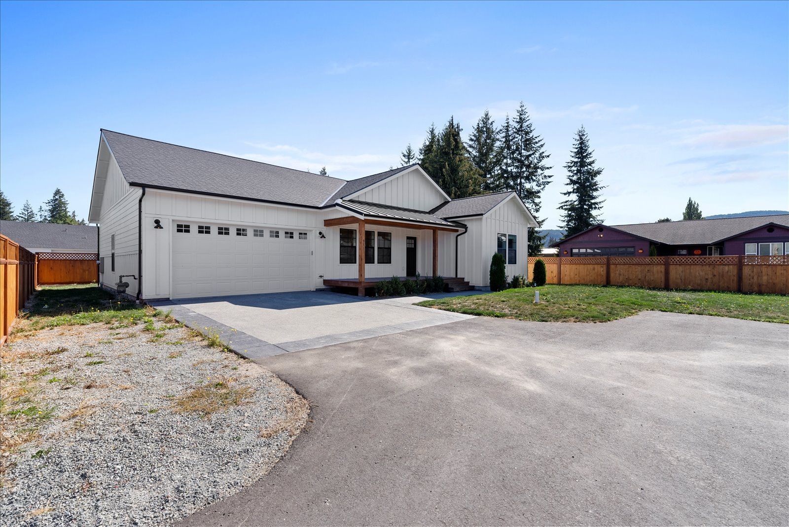 A white house with a garage and a driveway in front of it.